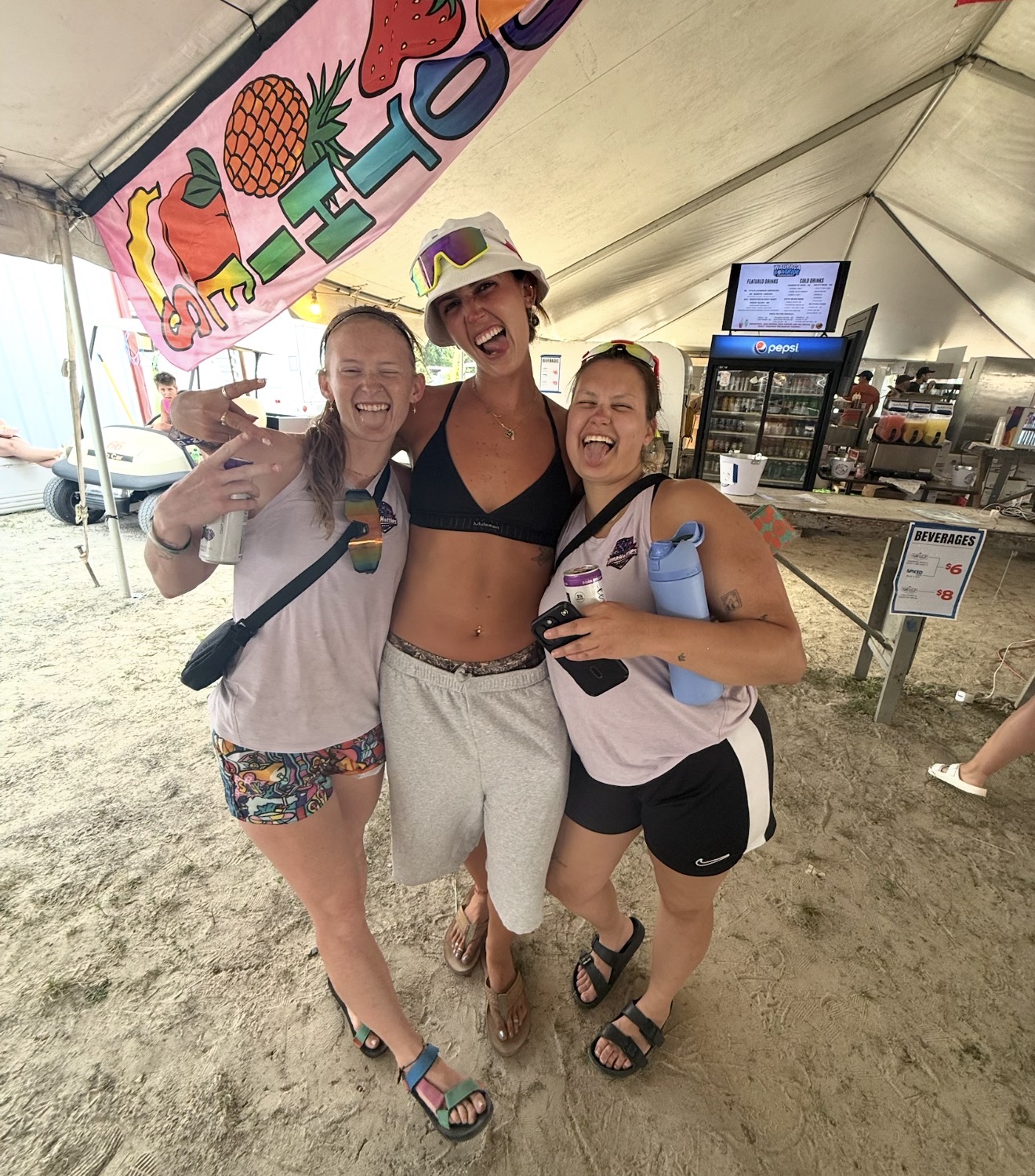 Three Omahotties teammates laughing under the tournament tent
