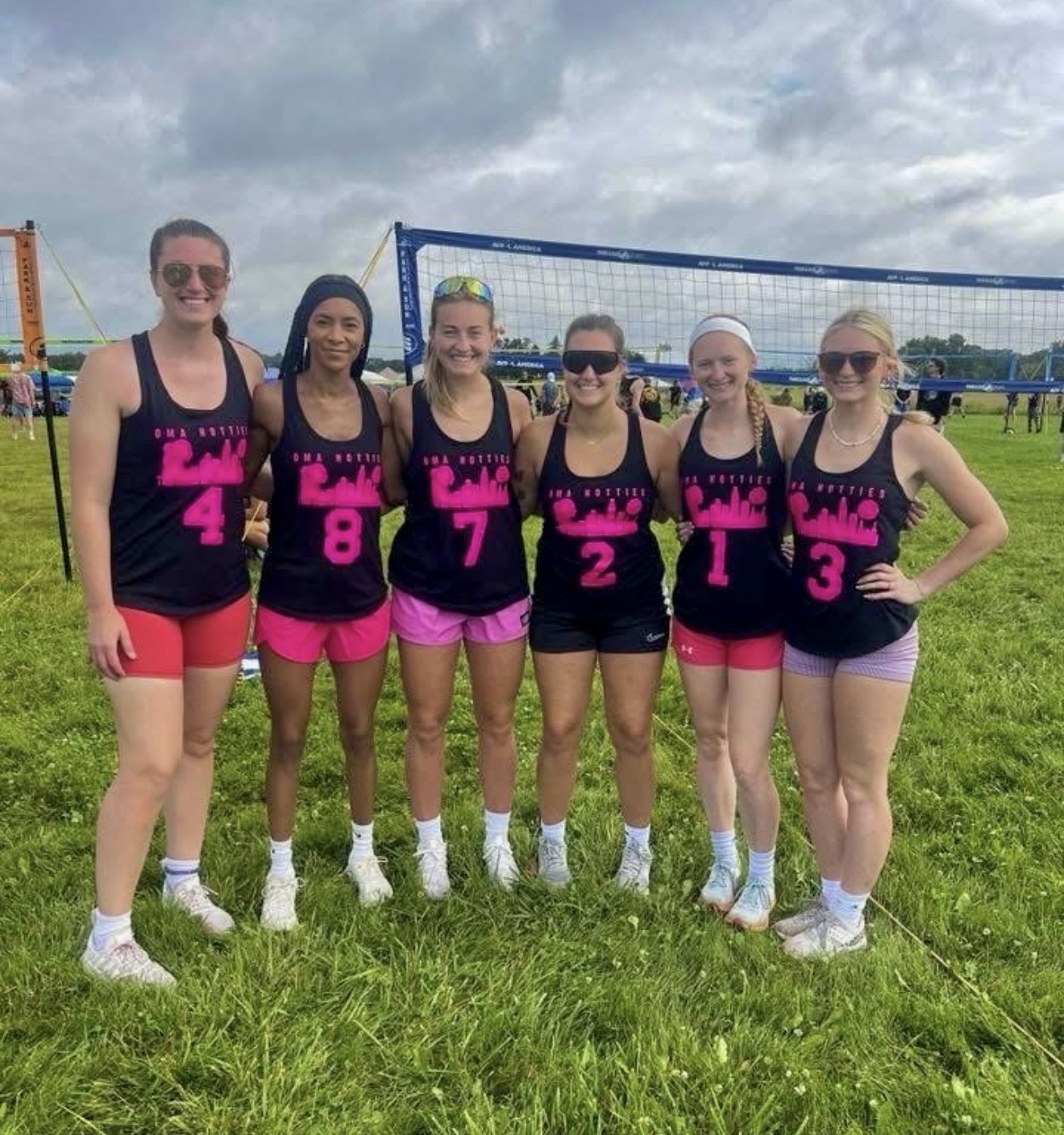 Omahotties squad in black and pink jerseys at an outdoor tournament
